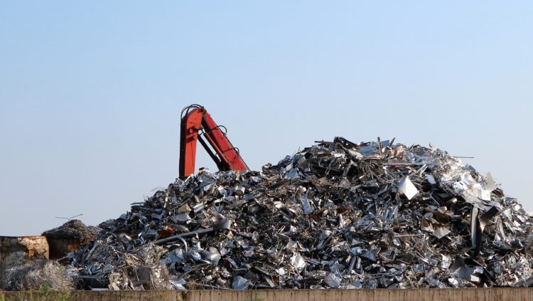 Tas de métaux recyclables avec grue de manutention sur site de récupération