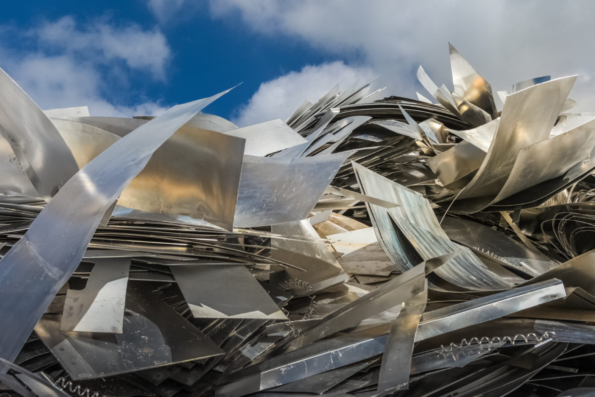 Déchets d'aluminium découpés et pliés reflétant la lumière sur site de récupération métallique